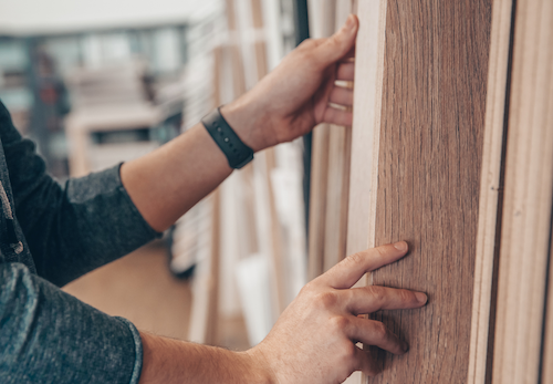 Customer choosing wooden flooring options in a showroom.
